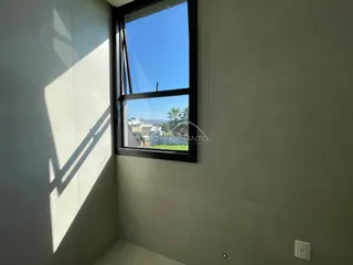 Foto de um canto interno mostrando uma janela com vista para o exterior.