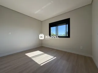Foto de um ambiente interno com piso de madeira e uma janela grande.