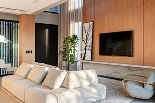 Sala de estar moderna com sofá claro e painéis de madeira.