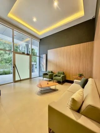 Sala de estar moderna com sofá claro e piso claro.