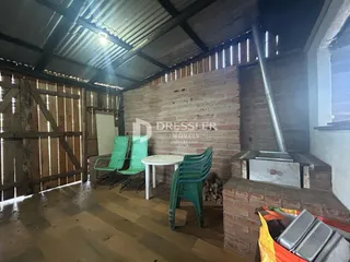 Imagem de uma sala com paredes de madeira rústica e piso de madeira.