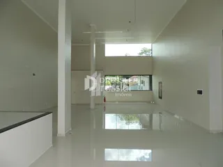 Vista interna de um corredor claro em uma residência.
