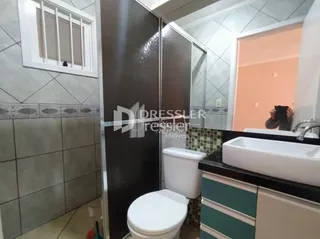 Foto de um banheiro interno com azulejos e louças sanitárias.