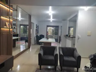 Sala de estar com sofás e detalhes em madeira clara.