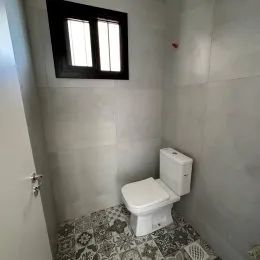 Foto do interior de um banheiro com revestimento de azulejos brancos.