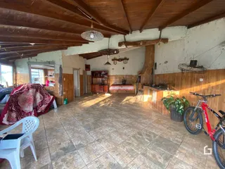 Ambiente interno amplo com teto de madeira aparente e piso de cerâmica.