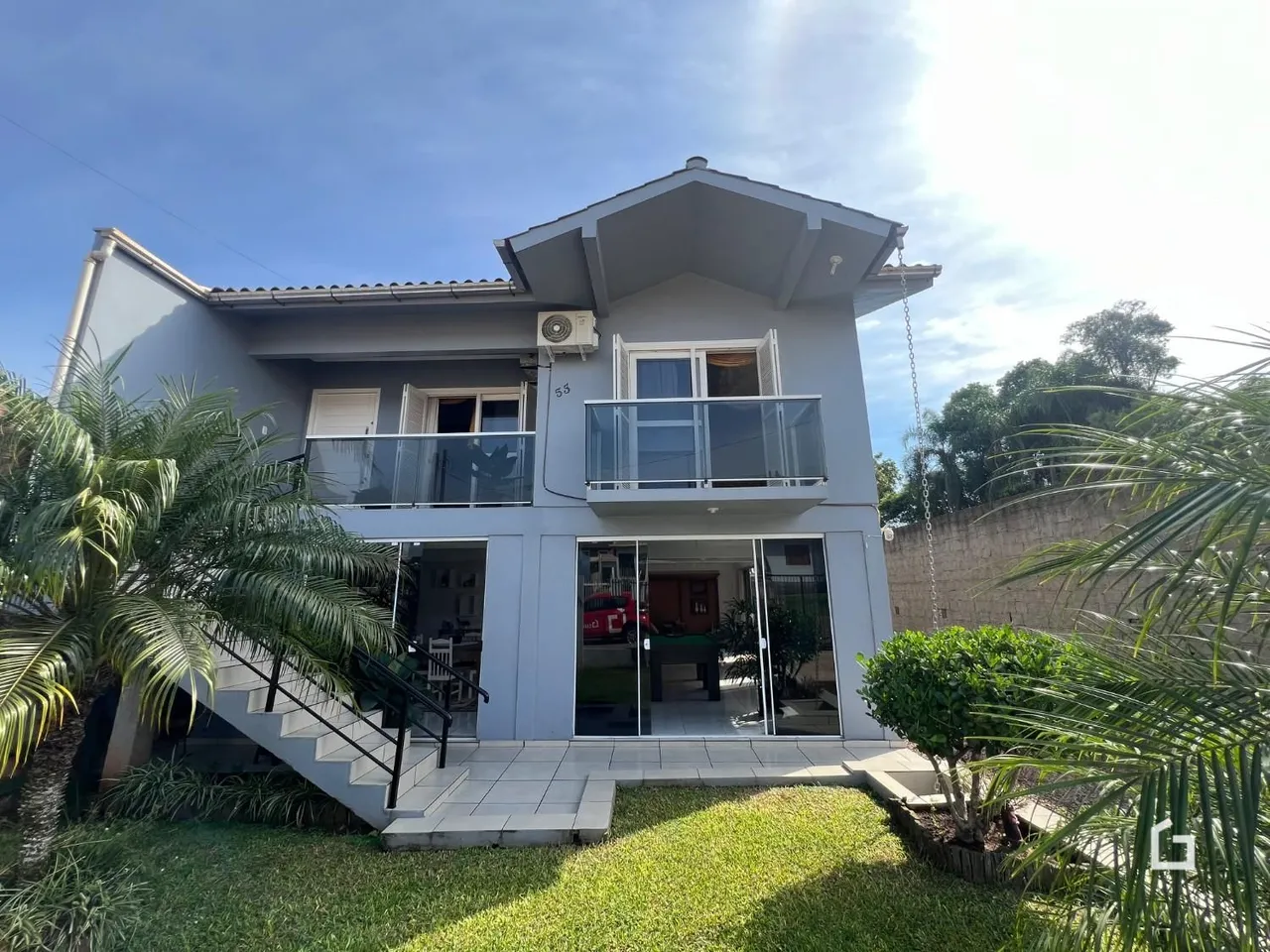 Fachada de uma casa moderna em Lajeado, Brasil, com varanda e jardim.