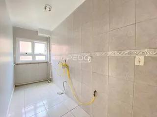Parede com revestimento cerâmico e piso claro em um ambiente interno.