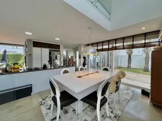 Sala de jantar com mesa e vista para o jardim externo.