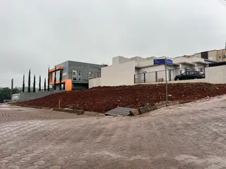 Fachada de uma casa moderna em Lajeado com paisagismo em terra.
