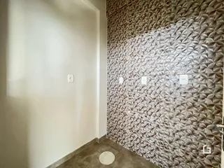 Hall de entrada com parede texturizada e tomada branca.