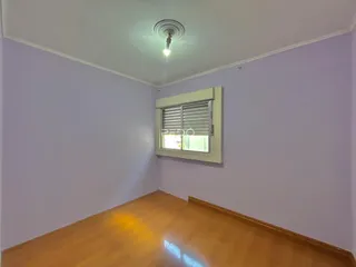 Foto de um cômodo interno com paredes roxas e piso de madeira.