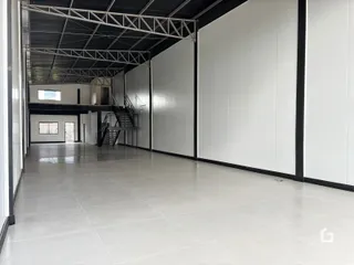 Corredor interno de uma propriedade com estrutura metálica exposta.