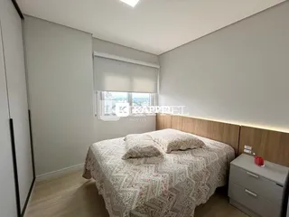 Quarto com cama e cabeceira de madeira em um imóvel.
