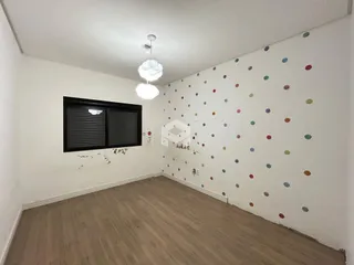 A sala apresenta paredes brancas com decoração de bolinhas coloridas.