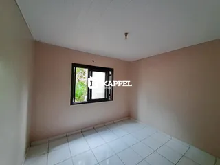 Foto interna de um cômodo com paredes claras e piso de cerâmica.