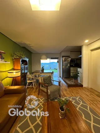 Sala de estar com piso de madeira e parede verde em um imóvel no Brasil.