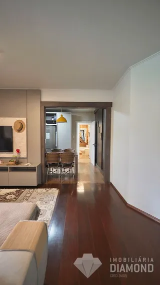 Hall de entrada com piso de madeira e porta de acesso a outra sala.