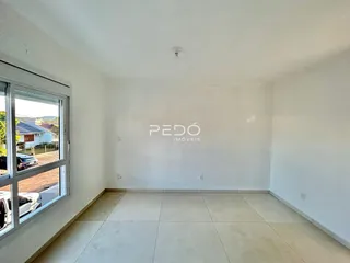Ambiente interno de uma sala com piso de cerâmica e janela.