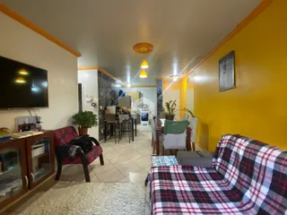 Sala de estar com paredes amarelas e móveis de madeira em um imóvel no Brasil.