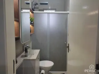 Foto de um banheiro interno com pia e vaso sanitário.