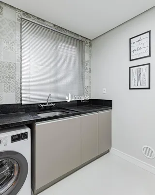 Vista da cozinha com bancada e máquina de lavar roupa.