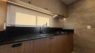Foto de uma cozinha moderna com bancadas escuras e armários de madeira.