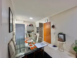 Uma sala de jantar com mesa de vidro e cadeiras em um imóvel no Brasil.
