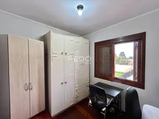 Quarto com armários brancos e janela de madeira.