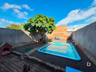 Foto de uma piscina externa em um pátio com muros de concreto.