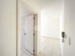 Hall de entrada com piso de cerâmica e paredes brancas.