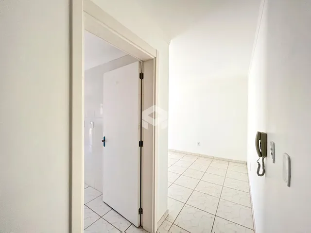 Hall de entrada com piso de cerâmica e paredes brancas.