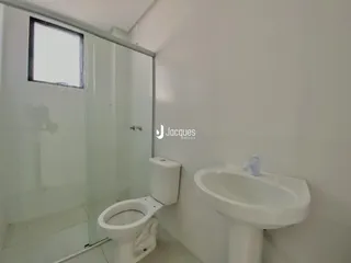 Banheiro com vaso sanitário e pia brancos.