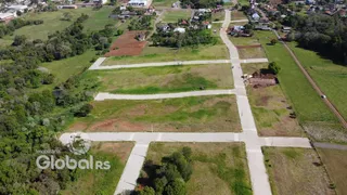 Vista aérea de um terreno aberto com áreas gramadas e caminhos.