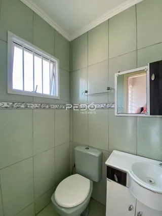 Foto de um banheiro interno com revestimento de azulejos verdes.