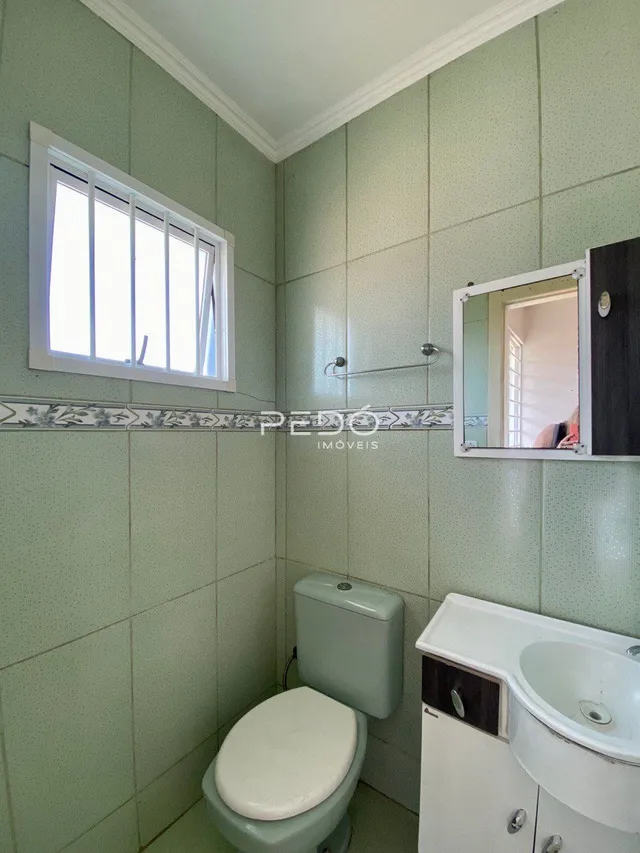 Foto de um banheiro interno com revestimento de azulejos verdes.