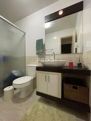 A foto mostra o interior de um banheiro com box de vidro.