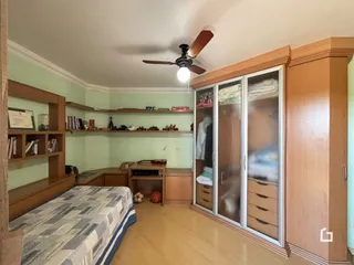 Quarto com armários embutidos e piso de madeira clara.