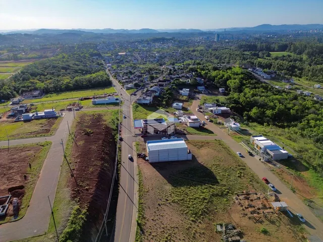 Vista aérea de uma área de terreno em Lajeado, Brasil, com vegetação e estruturas dispersas.
