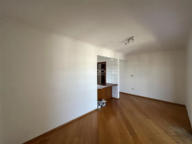 Interior de uma área com piso de madeira e paredes brancas.