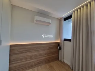 Sala de estar com painel de madeira e piso de madeira clara.