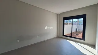Ambiente interno de uma sala com paredes brancas e piso claro.