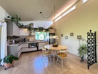 Foto de uma cozinha e sala de jantar com armários e mesa de madeira.