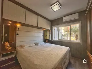 Quarto com cama e armários em um ambiente com painéis de madeira.