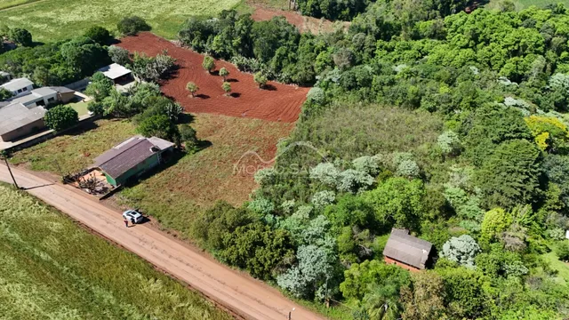 Vista aérea de uma propriedade rural com vegetação densa e área de terra.