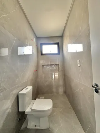 Hall de banheiro com revestimento em mármore cinza claro.