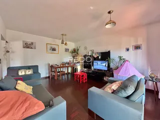 Sala de estar com sofá e mesa de jantar em ambiente interno.