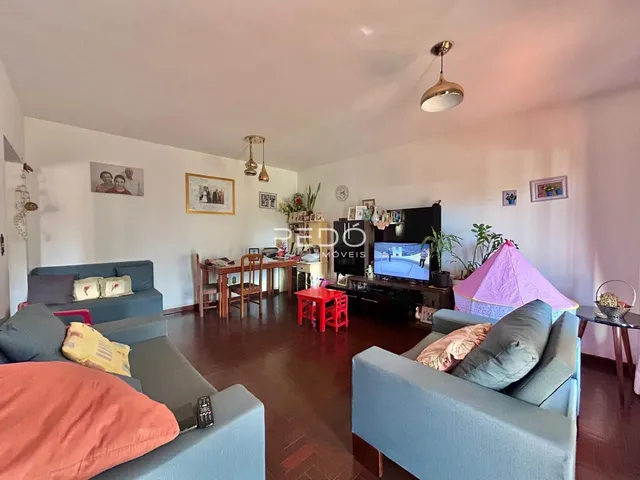 Sala de estar com sofá e mesa de jantar em ambiente interno.