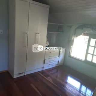 Interior com armários brancos e piso de madeira em um ambiente residencial.
