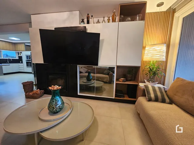 Sala de estar moderna com lareira e móveis brancos.